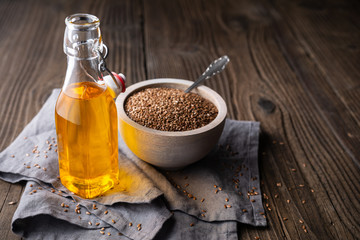 Flaxseed oil in a glass bottle, decorated with whole seeds with copy space