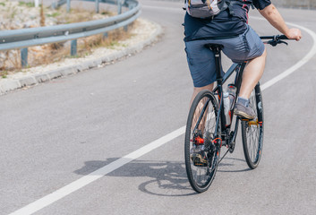 Fototapeta premium A caucasian male biker rides his bike uphill, wearing professional biking mountain biking gear