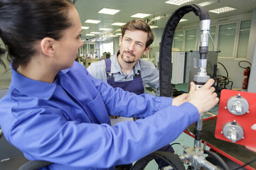 female worker connecting hose to machinery