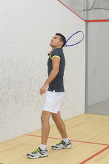 young man is playing tennis indoors