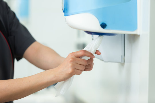 hands pulling paper towel from a dispenser