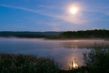 colorful moon on autumn lake at dawn
