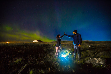 Fototapeta na wymiar Reykjanes Skaginn, Iceland »; August 2017: A couple of tourists on the Reykjanes peninsula under the northern lights