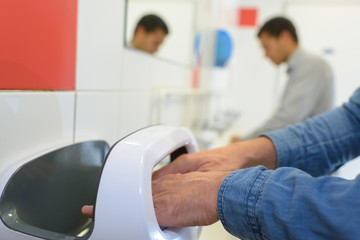 closeup of male hands in contactless air hand dryer