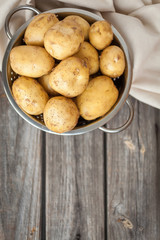 Raw potato. Fresh new potatoes on wooden background. Top view