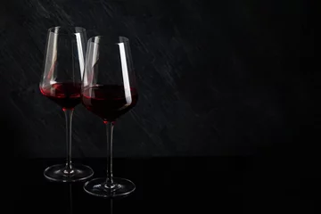 Fotobehang Bottle and glass of red wine on black background © Irina Burakova