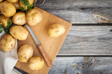 Raw potato. Fresh new potatoes on wooden background. Top view