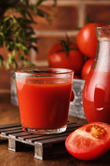 Tasty Tomato juice in a glass with ripe red tomatoes.
