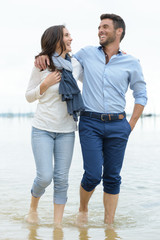 couple walking barefoot along the shoreline