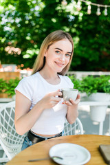Beautiful young girl having coffee at cafe