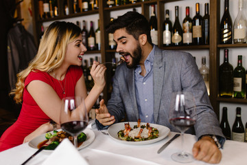 Beautiful young romantic couple dating at night in pub.