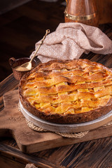 Homemade sweet pie cake with peach on white board on wooden rustic background