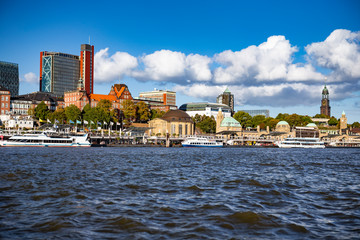 Naklejka premium Hamburg embankment on the Elbe River with ships, boats and stops of river transport on pontoons, port area Hafen city. Hamburg, Germany.
