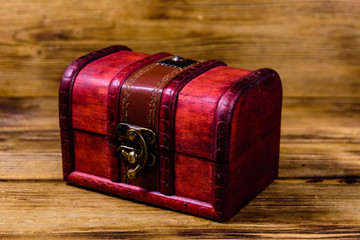 Closed vintage chest from red wood on wooden background