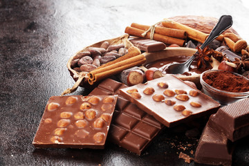Chocolate bar pieces and melting swirl cocoa. Sweet food photo concept. The chunks of broken chocolate on table