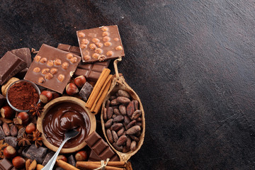 Chocolate bar pieces and melting swirl cocoa. Sweet food photo concept. The chunks of broken chocolate on table