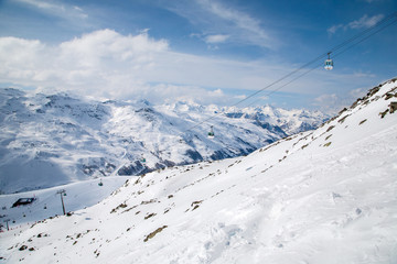 Fototapeta na wymiar Panoramic view of ski resort three valleys and big lift in french alps - Vacation and travel concept - Winter high season opening with people having fun on mountain - Focus on sport equipment