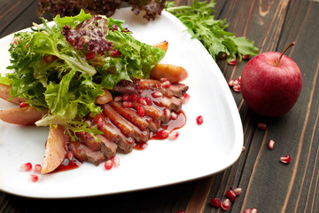 Salad with duck brisket suvid on a wooden background