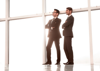 business background.two businessmen standing near the office window