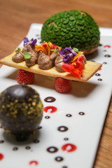 Dark chocolate egg with chou bun stuffed with chocolate cream. Creative restaurant dessert concept.