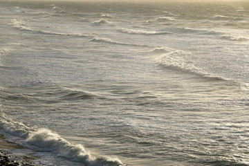 empty ocean with waves in warm evening light as background