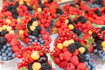 boxes with ripe berries and fruits laid out in a row at the market, store
