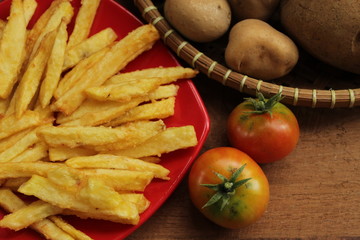 conceptual photo of homemade french fries on red plate
