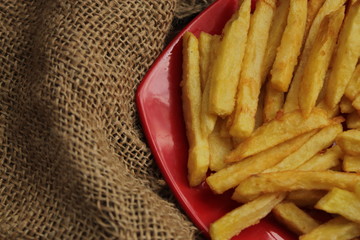 conceptual photo of homemade french fries on red plate