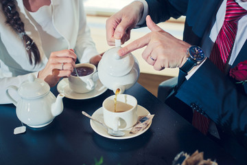 Tea for two. Married people drink tea at a wooden table in Italy.