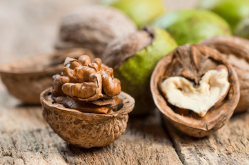 Fototapeta na wymiar Ripe and raw whole big walnut kernel with thin shell on wooden rustic backdrop. healthy nut food for brain. Fresh walnuts background concept