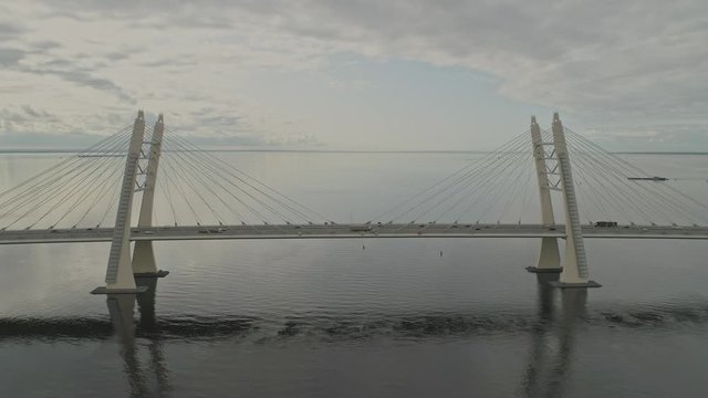 Aerial view fly over traffic on cable bridge above river