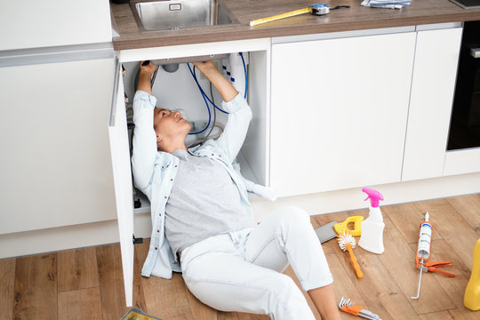 Woman Fixing Kitchen Sink