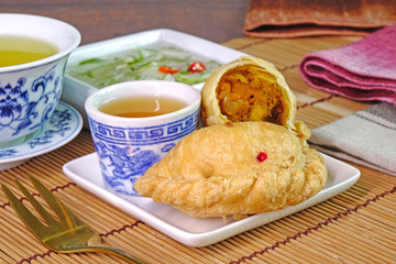Curry puff. Chicken curry puff (or Karipap) is a snack of Southeast Asian origin. It is a small pie consisting of curry with chicken and potatoes in a deep-fried or baked.