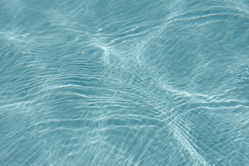 Close up full frame view of the reflecting water surface of a sunlit swimming pool