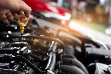 Man service mechanic maintenance inspection service maintenance car Check engine oil level car in garage showroom dealership blurred background.