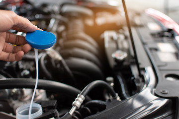 Obraz premium Man service mechanic maintenance inspection service maintenance car Check engine with fill water add water to the wiper car in garage showroom dealership blurred background For automotive automobile