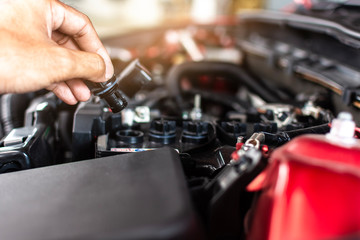 Obraz premium Man service mechanic maintenance inspection service maintenance car Check engine oil level car in garage showroom dealership blurred background.