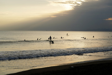 Fototapeta na wymiar Surfers in the evening of backlight