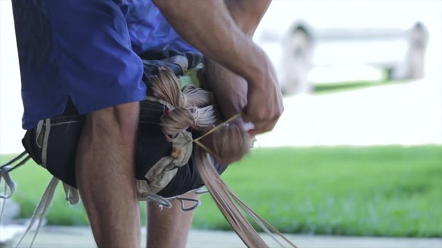 Hands close up packing skydive parachute canopy lines in deployment bag. Extreme sports safety equipment maintenance. Modern parachute gear used for sport skydive jumping. 
