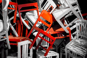 Wooden chairs. Outstanding red chair of black and white Pile of chairs. Chairs conceptual.