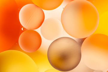 bright oily drops in water with colorful background, close-up 