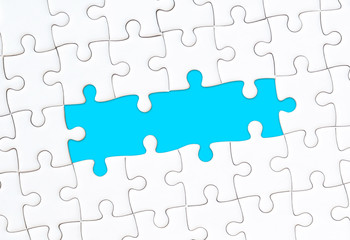 White jigsaw puzzle with empty space for your text and blue background
