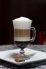 cup of coffee with whipped cream on wooden background