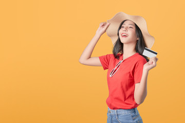 Beautiful Asian woman good skin wearing hat  holding credit card payment on orange background.