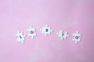 Puzzle pieces with abbreviation LGBTQ on color background