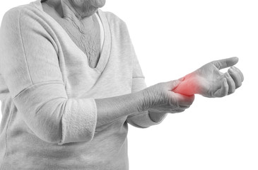 Senior woman suffering from pain in wrist on white background