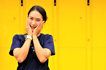 Portrait asian woman on yellow luggage locker background