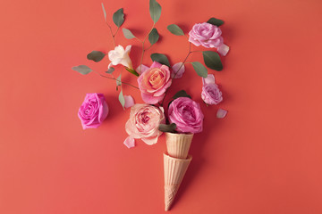 Waffle cones with beautiful roses on color background