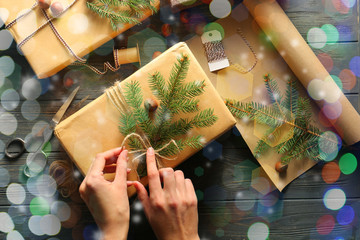 Naklejka na ściany i meble Woman preparing Christmas gift on wooden table