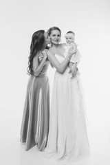 Fototapeta na wymiar wedding fashion concept for women of all ages. A group of women in long evening dresses on a white background